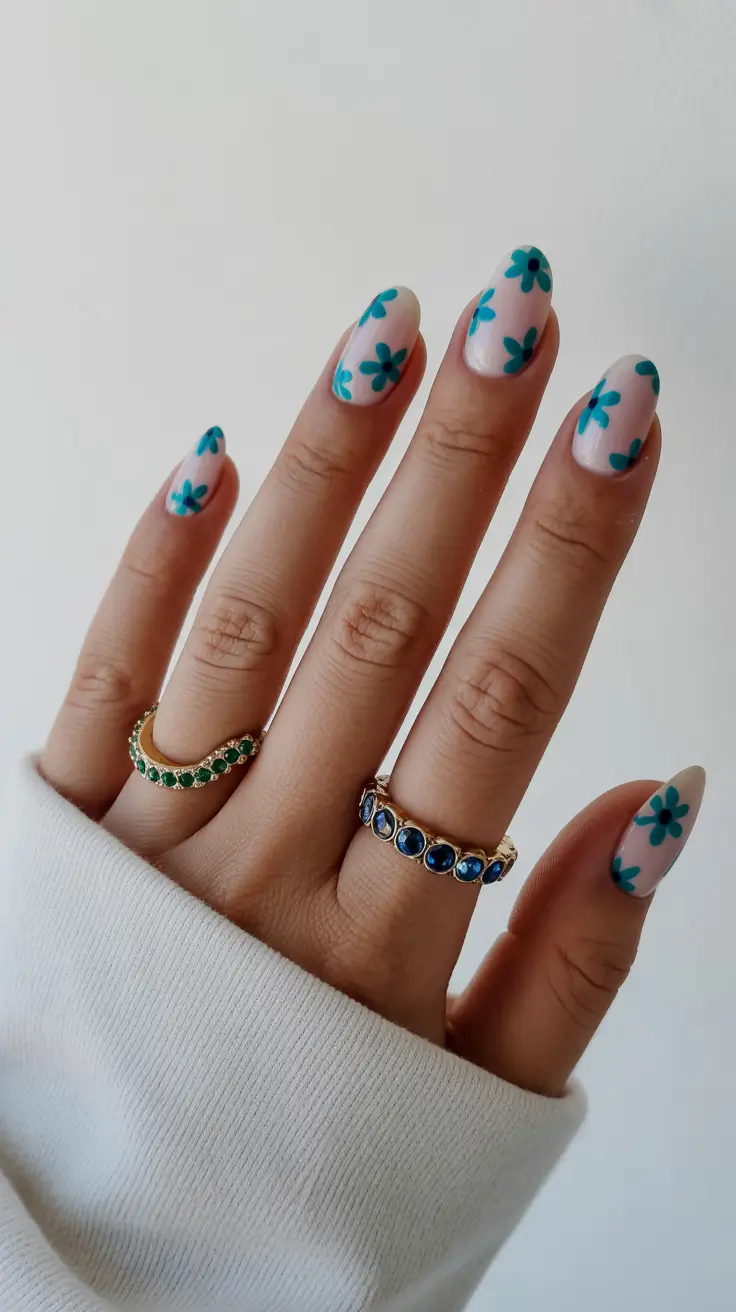best spring short nails to try 2026 Sheer Nude Short Nails with Teal Flower Pattern
