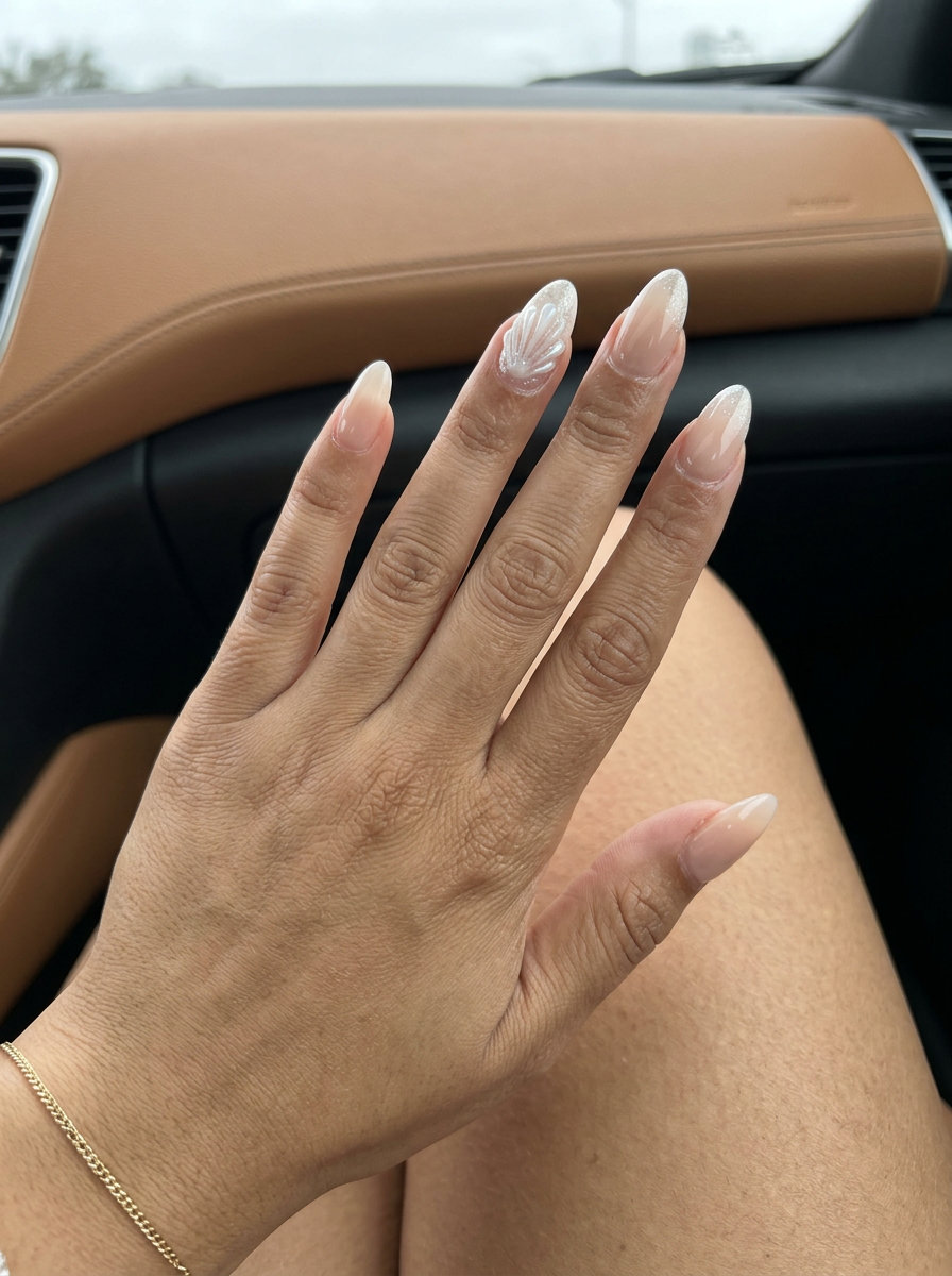Bohemian Seashell Almond Nails - Shell Summer Nails 2026 Seashell Glitter Almond nails for shell summer nails 2026. Bohemian nude with iridescent white shell art.