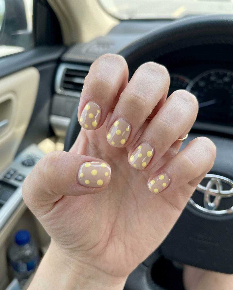 Short summer nails 2026: Butter yellow dots on nude short round nails for casual picnic or everyday wear.