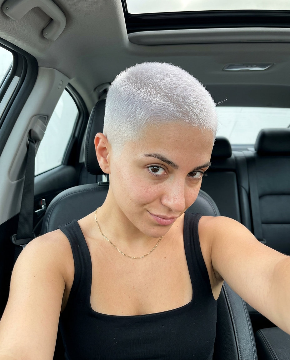 ultra-short platinum buzz haircut with skin fade and stark white color for festivals
