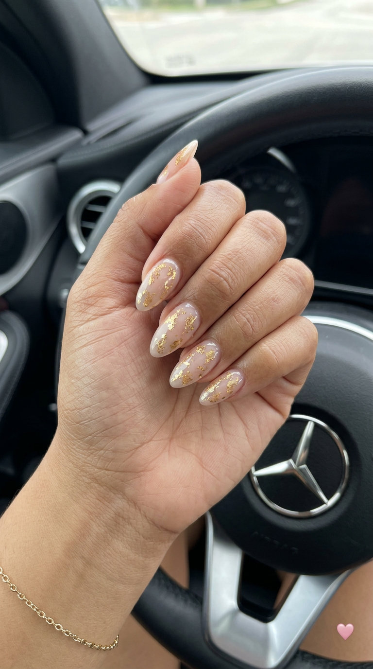Gilded Goddess Nails 2026: Wedding Guest Glam Sheer nude nails with gold foil flakes for vibrant nails summer 2026. Elegant wedding guest look.