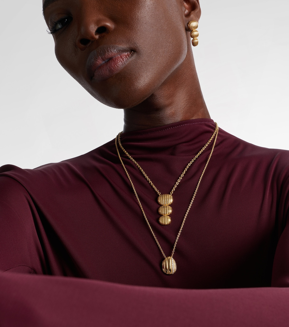 Maroon Mock-Neck Top Paired with Layered Gold Oval Pendants Maroon Mock-Neck Top Paired with Layered Gold Oval Pendants — Locket Necklaces 2027