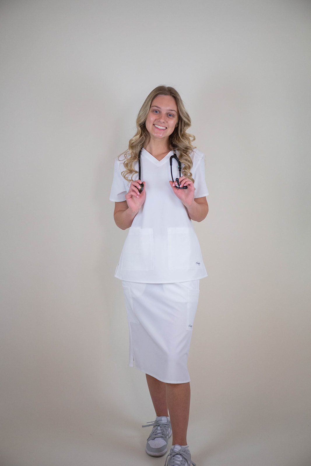 White V-Neck Scrub Top with a Fitted Scrub Skirt and Grey Sneakers White V-Neck Scrub Top with a Fitted Scrub Skirt and Grey Sneakers — Scrubs Outfits 2027