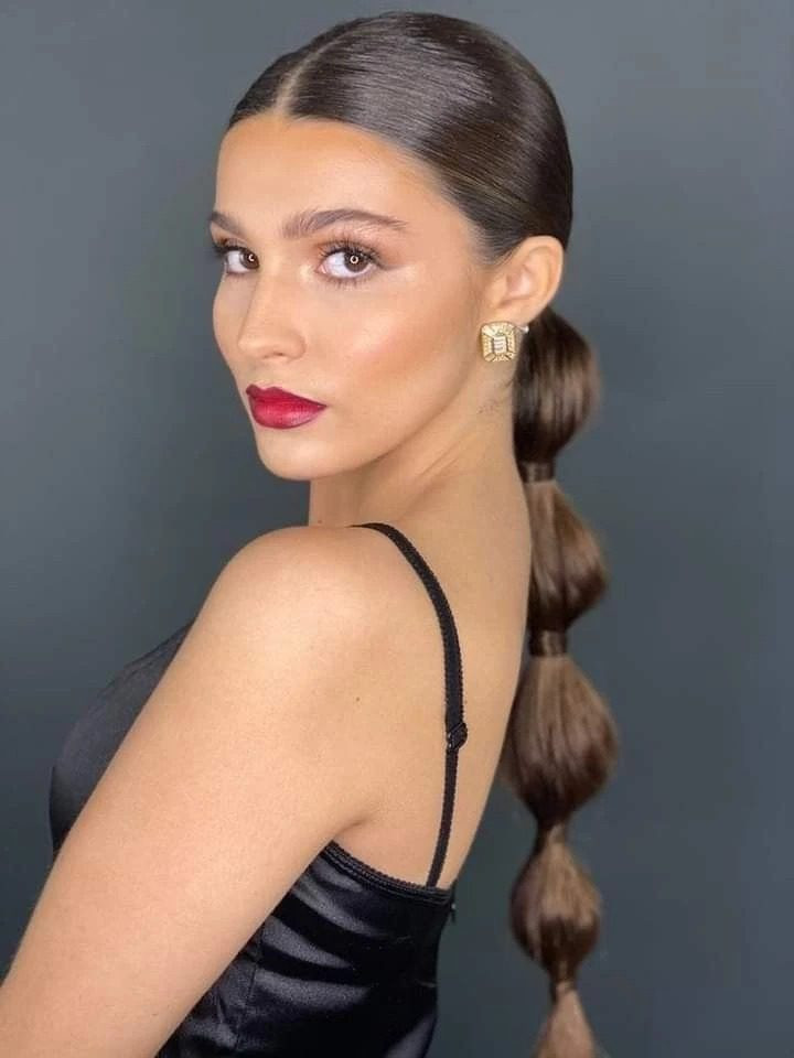 Sleek Dark Blonde Bun With Large Black Bow — Christmas Hairstyles 2026
