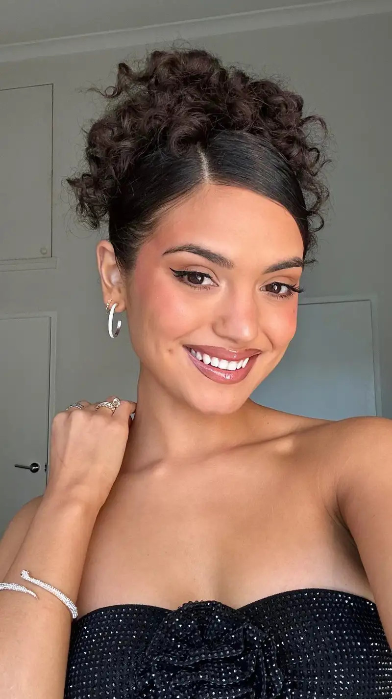 Textured High Bun With Face-Framing Tendrils — Prom Hairstyles 2027 for Curly Hair