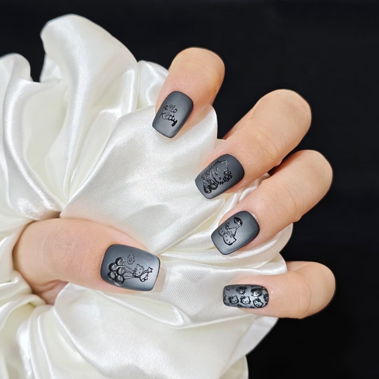 Short Square Matte Black Embossed Hello Kitty Nails, Close-Up Take Short Square Matte Black Embossed Hello Kitty Nails, Close-Up Take — Black Hello Kitty Nails 2027