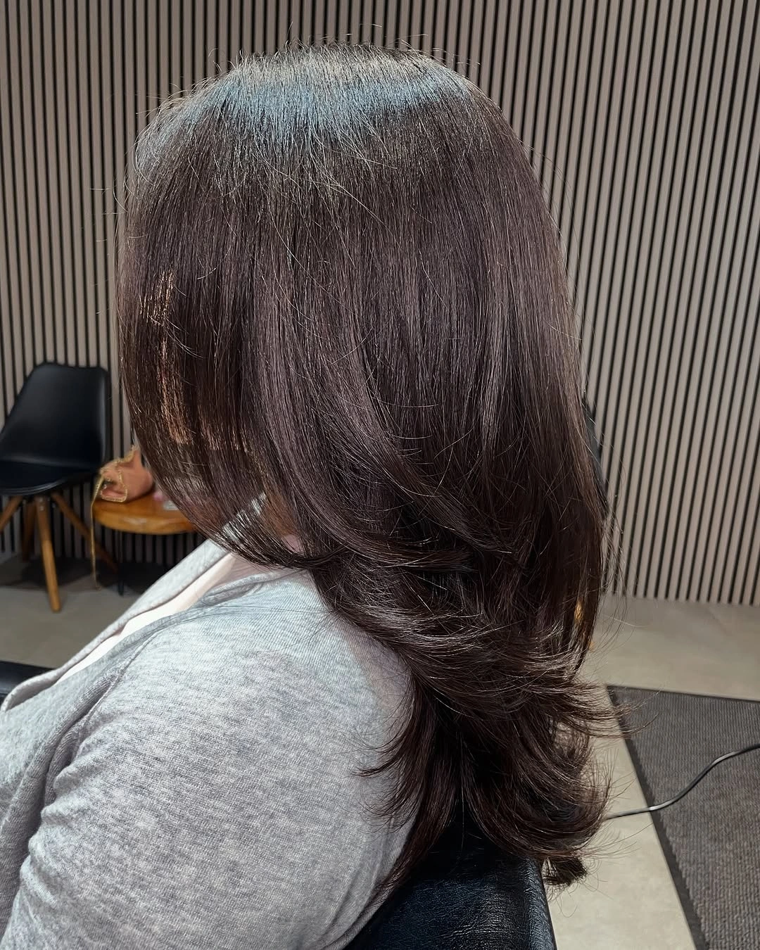 Low Layers Keep the Upper Shape Smooth Back view of long brunette hair with low curved layers