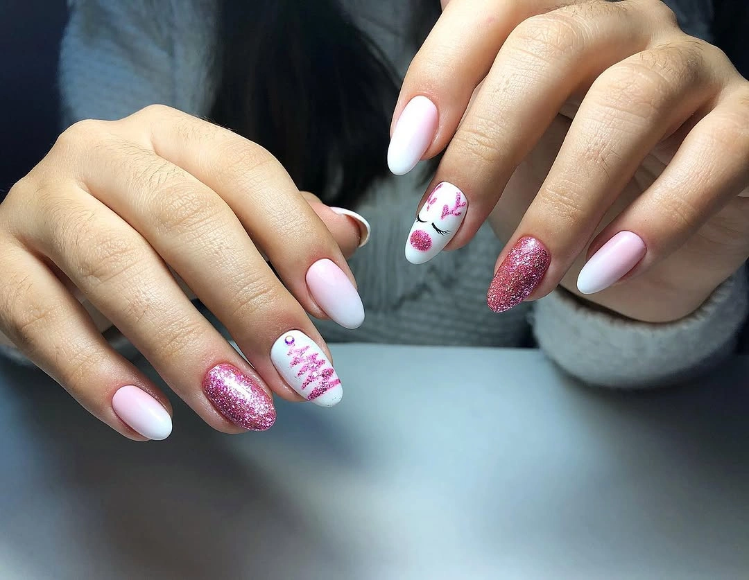 Pink Ombre Christmas Nails With Glitter Accents Pink ombre nails with glitter tree and stylized reindeer accent