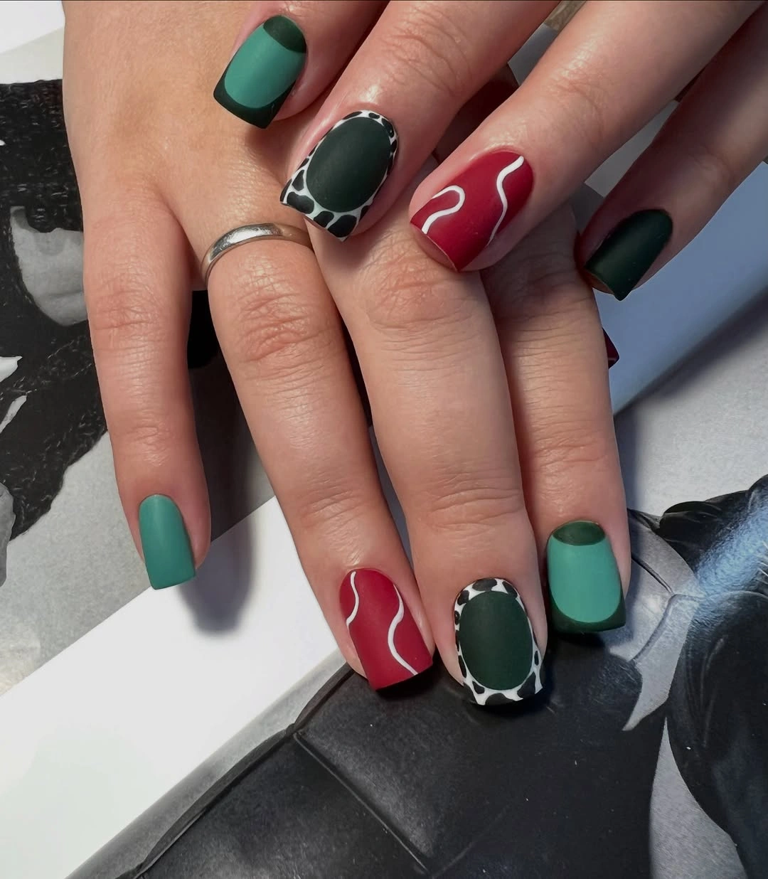 Matte Green and Red Nails With Graphic Curves Short matte green and red nails with black and white accents