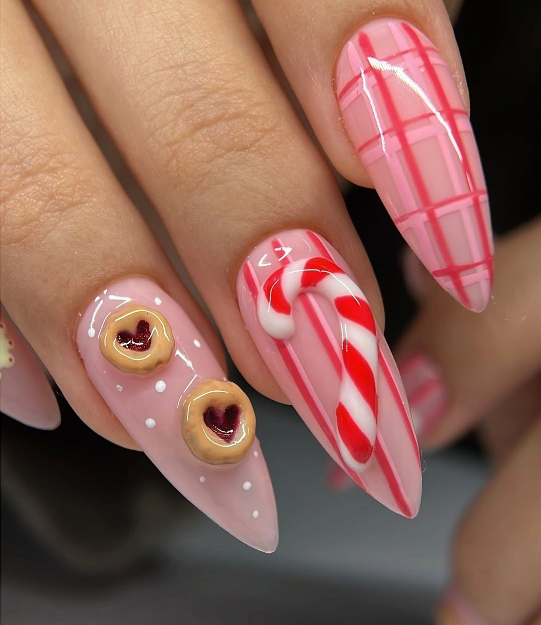 Pink Christmas Nails With Candy-Inspired Dimension Long pink nails with plaid, candy cane, and raised heart details