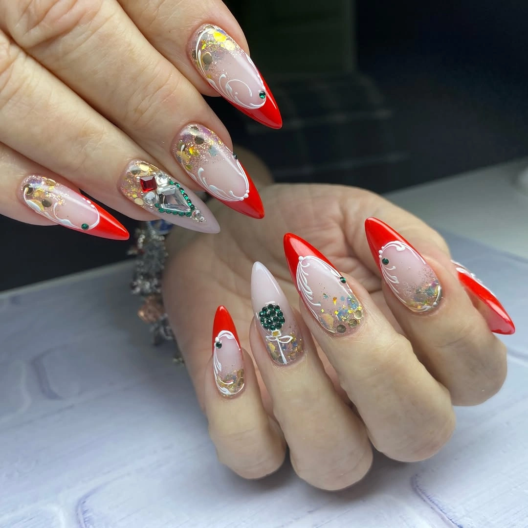 Long Red Tips With Jeweled Holiday Detail Long pointed red-tip nails with white swirls and jewel-like accents