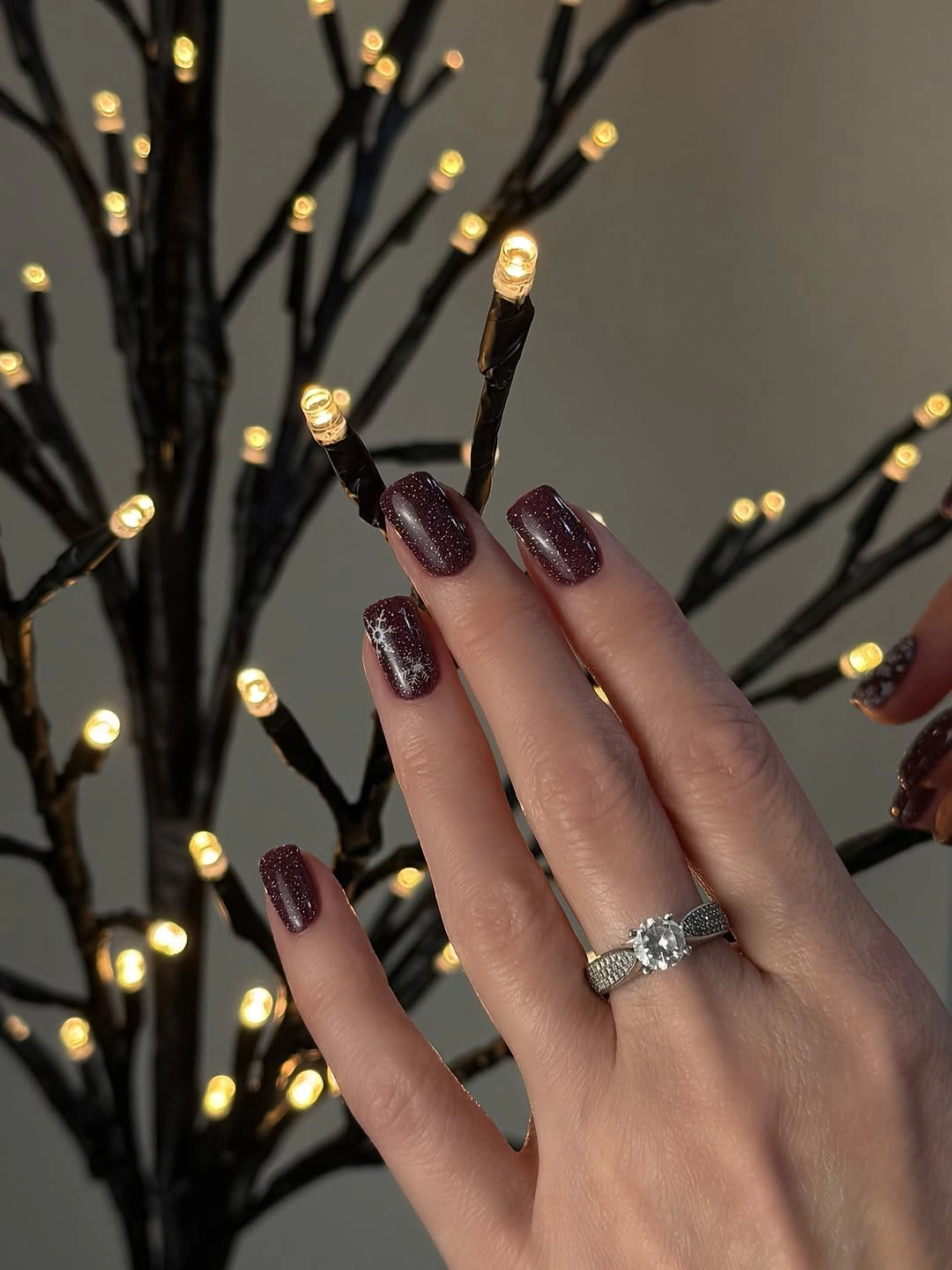 Burgundy Shimmer Nails With a Snowflake Accent Dark burgundy shimmer nails with pale snowflake-like winter detailing