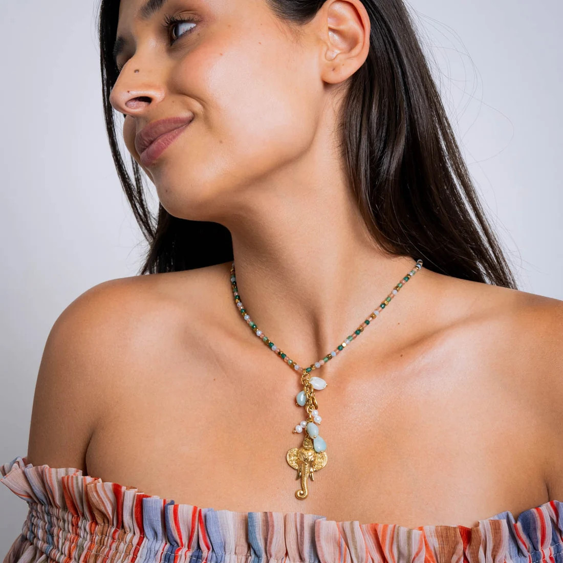 Off-the-Shoulder Top Styled with a Multi-Colored Beaded Elephant Pendant Off-the-Shoulder Top Styled with a Multi-Colored Beaded Elephant Pendant — Locket Necklaces 2027