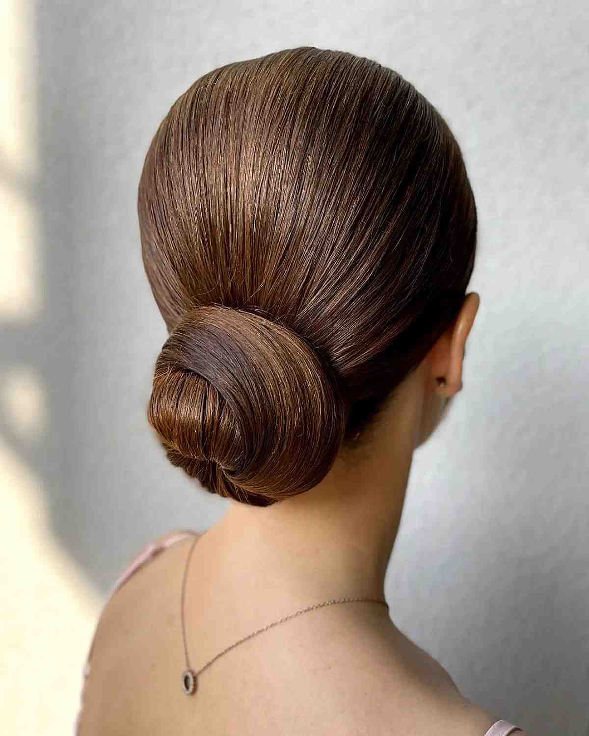 Classic Medium Brown Low Bun Classic Medium Brown Low Bun — Quick Quinceanera Hairstyles 2027