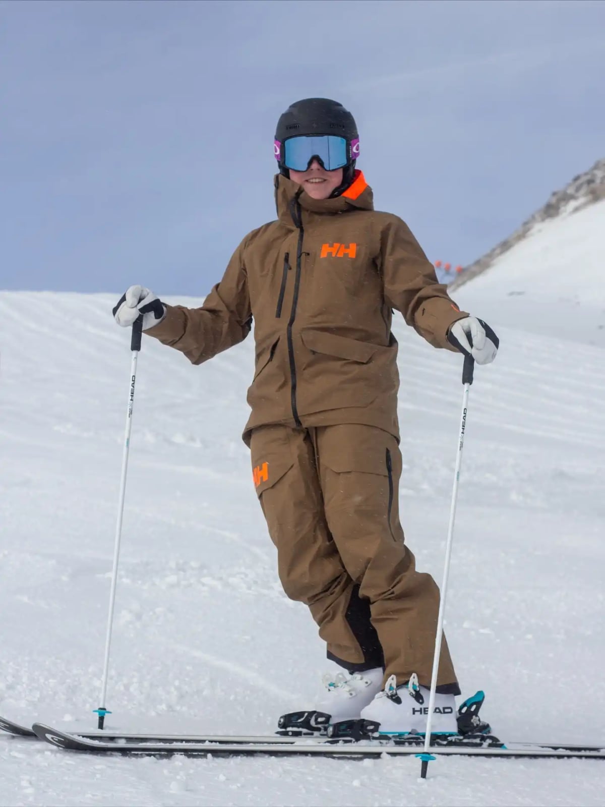Brown technical ski suit with orange hood trim Brown technical ski suit with orange hood trim — Ski Trip Outfits 2027
