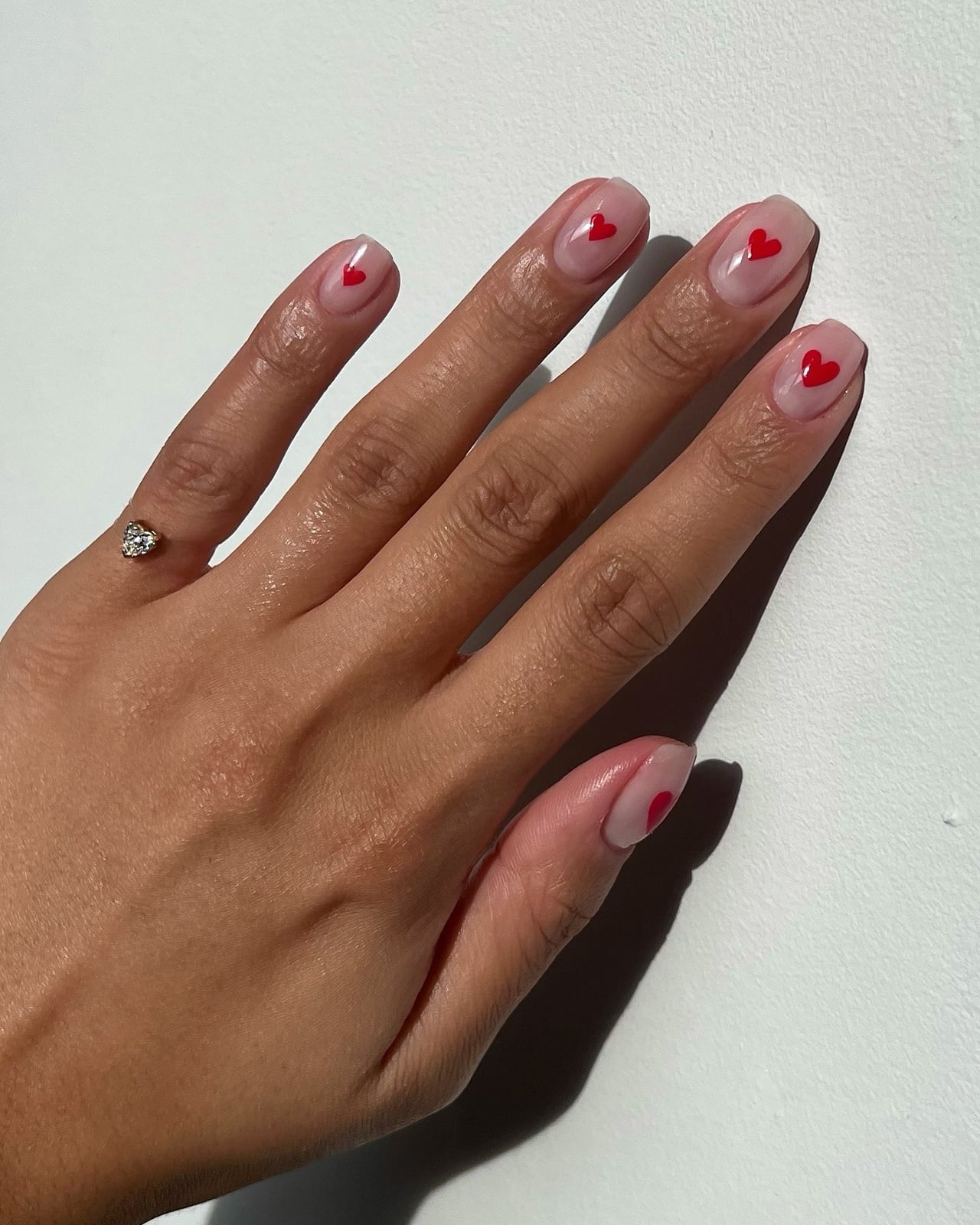 Medium Almond Nude With Scattered Red Heart Decals, Close-Up Take Medium Almond Nude With Scattered Red Heart Decals, Close-Up Take — Small Heart Nails 2027