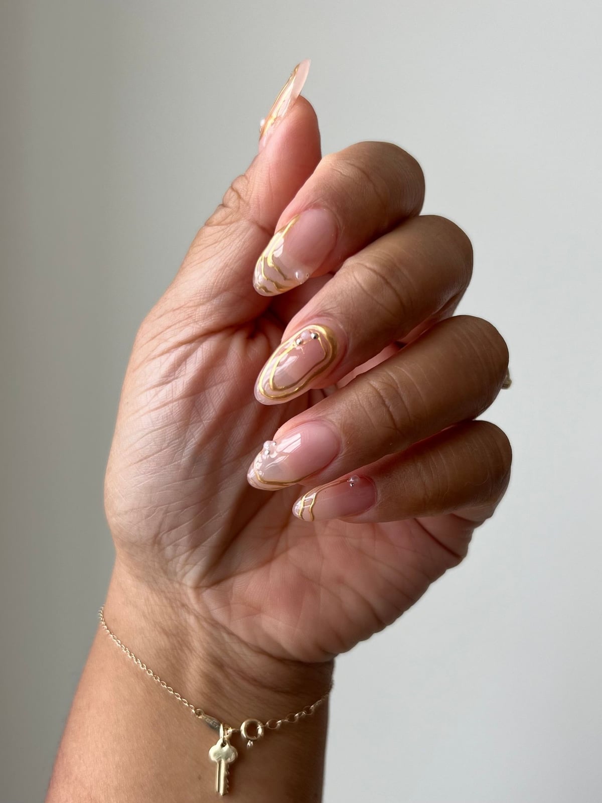 Gold Foil Swirl Sheer Nude Almond Nails, Close-Up Take Gold Foil Swirl Sheer Nude Almond Nails, Close-Up Take — Spring Wedding Nails 2027