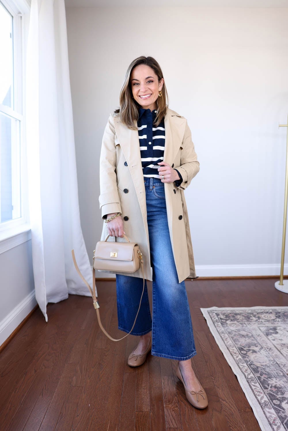 Beige trench coat with striped sweater and cropped jeans Beige trench coat with striped sweater and cropped jeans — Winter to Spring Transition Outfits 2027