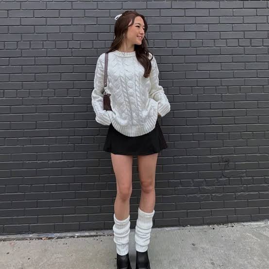 White cable knit sweater with black mini skirt and leg warmers White cable knit sweater with black mini skirt and leg warmers — Winter to Spring Transition Outfits 2027